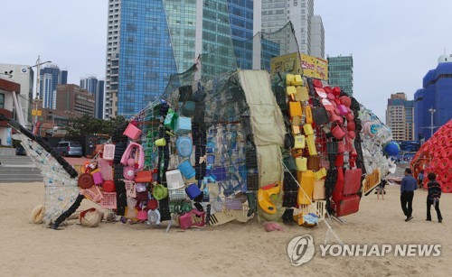 해운대 등장한 플라스틱 물고기 (부산=연합뉴스) 차근호 기자 = 7일 오후 부산 해운대해수욕장 백사장에 열리는 '제2회 비치코밍 페스티벌'에서 시민들이 플라스틱 쓰레기 심각성을 알리기 위해 설치된 대형 플라스틱 물고기 조형물을 바라보고 있다. 2019.10.7 ready@yna.co.kr