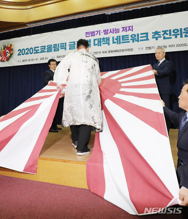 【서울=뉴시스】 장세영 기자 = 캘리아티스트 권도경 작가가 지난 22일 서울 여의도 국회 의원회관에서 열린 전범기와 방사능 저지 2020도쿄올림픽 글로벌 네트워크 추진위원회 발대식에서 참석해 일본 전범기인 욱일기를 찢는 퍼포먼스를 하고 있다. 2019.10.22. photothink@newsis.com