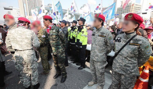 지난 2017년 3월 박근혜 전 대통령 탄핵 기각 촉구 집회에서 참가자들이 군복을 입고 서있다. /연합뉴스