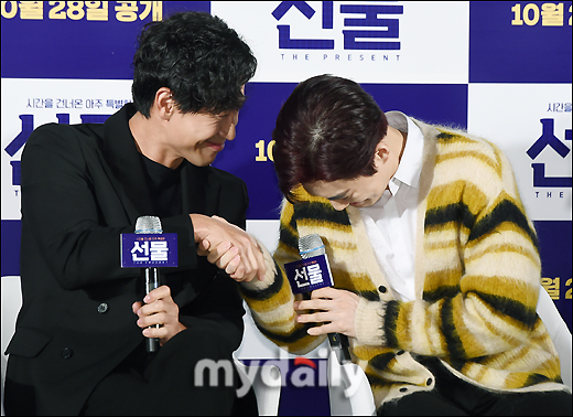 Actors Shin Ha-kyun and Suho (EXO Suho) shake hands at a special screening and meeting of the movie Gift (director Huh Jin-ho, production first project) held at the entrance of Lotte Cinema Counter in Jayang-dong, Seoul on the morning of the 28th.The movie Gift is a delightful and youthful comedy about the story of a suspicious man from the past appearing in front of the young people who gathered to realize a sparkling idea.Actors Shin Ha-kyun, EXO leader Suho, Kim Seul-gi and Yoo Soo-bin will appear; it will be released online October 28.