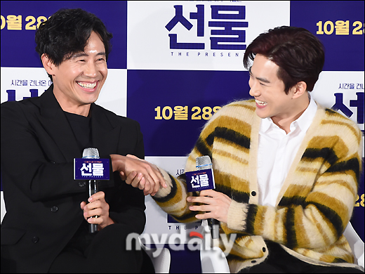 Actors Shin Ha-kyun and Suho (EXO Suho) shake hands at a special screening and meeting of the movie Gift (director Huh Jin-ho, production first project) held at the entrance of Lotte Cinema Counter in Jayang-dong, Seoul on the morning of the 28th.The movie Gift is a delightful and youthful comedy about the story of a suspicious man from the past appearing in front of the young people who gathered to realize a sparkling idea.Actors Shin Ha-kyun, EXO leader Suho, Kim Seul-gi and Yoo Soo-bin will appear; it will be released online October 28.