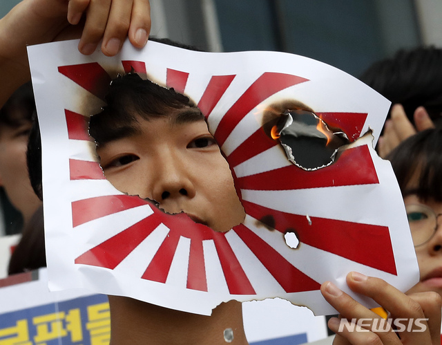 【서울=AP/뉴시스】지난 7월29일 서울의 미쓰비시(三菱)중공업 앞에서 열린 일본의 한국에 대한 수출규제 규탄 시위 도중 한 학생이 일본 욱일기를 그린 종이를 불태우고 있다. 일본 관리들은 전시 강제징용을 둘러싸고 한국과 일본 간 관계가 냉각되고 있는 것과 관련, 한국이 내년 도쿄 올림픽을 양국 마찰의 새 전선으로 삼을 것을 두려워하고 있다고 영국 파이낸셜 타임스(FT)가 13일(현지시간) 보도했다. 2019.10.14
