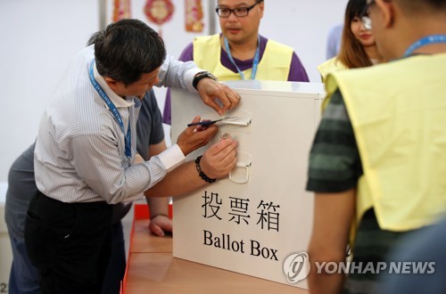 투표함 개봉하는 관계자 (홍콩=연합뉴스) 김인철 기자 = 홍콩 구의원 선거일인 24일 오후 홍콩 구룡공원 수영장에 마련된 투표소에서 관계자들이 개표작업을 위해 투표함을 개봉하고 있다. 2019.11.25 yatoya@yna.co.kr