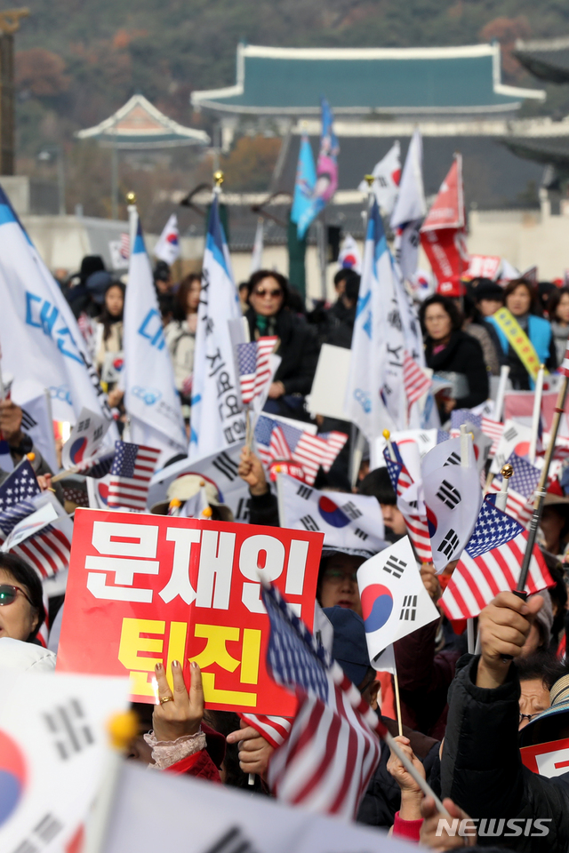 [서울=뉴시스]김병문 기자 = 정부를 규탄하는 시민들이 지난 23일 오후 서울 종로구 광화문 교보빌딩 앞에서 문재인하야범국민투쟁본부 주최로 열린 '대한민국 바로세우기 국민대회'에 참석해 태극기를 흔들고 있다. 2019.11.23. dadazon@newsis.com