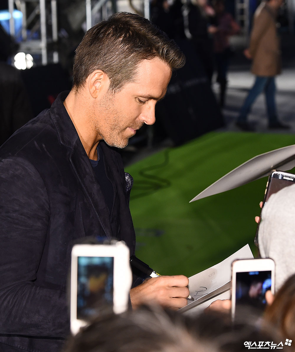 Actor Lion Reynolds, who attended the Netflix 6 Underground green carpet event at Seoul Dongdaemun Design Plaza (DDP) on the afternoon of the 2nd, is responding to a request for a sign by a fan.