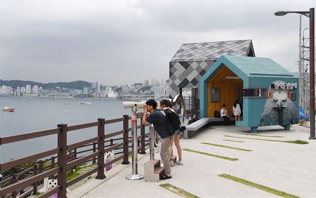 흰여울문화마을을 찾은 관광객들이 전망대에서 망원경으로 맞은편 송도를 비롯, 마을 앞 전경을 감상하고 있다.