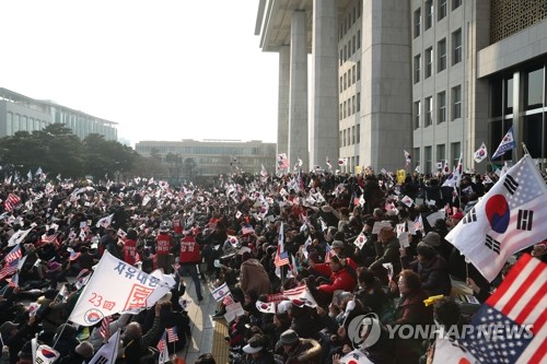 국회 둘러싼 '태극기' 물결 (서울=연합뉴스) 신준희 기자 = 자유한국당의 '패스트트랙 법안 날치기 상정 저지 규탄대회'에 참가했던 보수단체 회원들이 16일 오후 서울 여의도 국회 본청 앞에서 선거법·공수처법 반대 집회를 계속하고 있다. 2019.12.16 hama@yna.co.kr