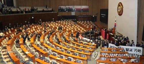 민주당 본회의장 입장      (서울=연합뉴스) 하사헌 기자 = 더불어민주당 의원들이 27일 오후 자유한국당 의원들이  '연동형비례대표제' 선거법 반대 현수막을 펼치고 의장석을 둘러싸고 있는 국회 본회의장에 입장하고 있다. 2019.12.27      toadboy@yna.co.kr  (끝)