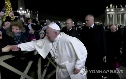 한 신도가 손을 잡아 당기자 얼굴을 찡그리는 교황 [로이터=연합뉴스]