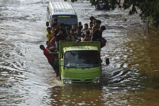 인도네시아 자카르타 주민들이 2일 트럭을 타고 침수 지역을 벗어나고 있다. [신화=연합뉴스]