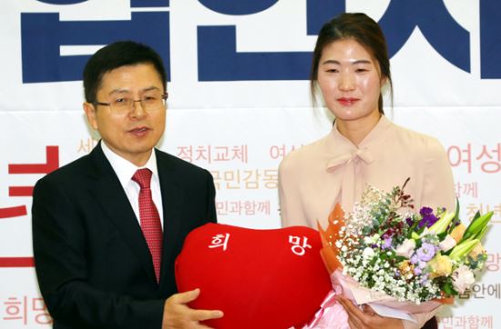 제21대 총선을 앞두고 자유한국당에 영입된 체육계 미투 1호인 김은희 씨가 8일 국회 의원회관에서 열린 한국당 영입인사 환영식에서 황교안 대표에게 당을 상징하는 빨간 쿠션을 건네받으며 기념촬영 하고 있다. 연합