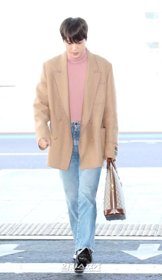 Kai is heading to the departure hall, sporting a nice airport fashion.Kai Crossing runway passes calmly
