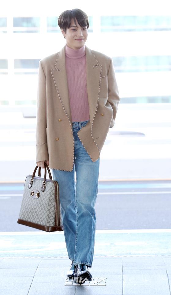 Kai is heading to the departure hall, sporting a nice airport fashion.Kai guns to Milan with only Smile
