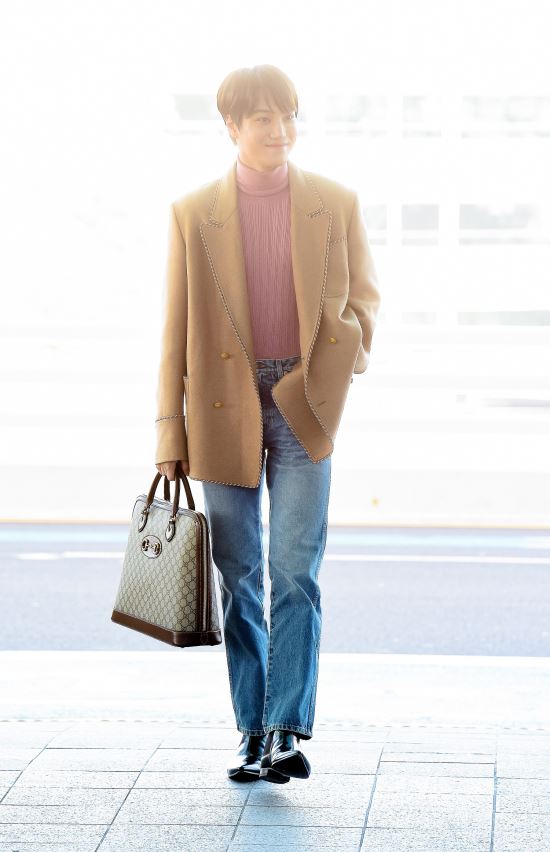 EXOs Kai left for Milan, Italy, on December 12 through Incheon International Airport.The 14th is for the Gucci 2020 autumn Winter Menz Collection Fashion show.Kai accessorised with a 2020 cruise collection by Gucci, wearing a carmel (dark beige) color jacket with patch detailing, a pink wool turtleneck and denim pants.Here he wore black leather ankle boots.Especially, it attracted attention with the Raj GG Supreme duffel bag which shows the hallsbit decoration of the Gucci logo.Kai is Guccis global ambassador; this Fashion show, which Kai will attend, will be a mens solo fashion show that will resume after the mens and womens integration show, which was introduced in 2017, at Gucci, to mark the finale of the 2020 Autumn Winter Milan mens fashion week.