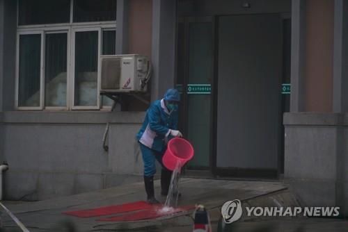 중국 우한의 병원 입구에서 청소 중인 직원 [AP=연합뉴스 자료사진]