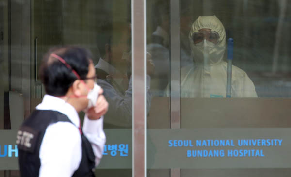 지난 1월 29일 신종 코로나바이러스 네 번째 확진자가 치료 중인 경기 성남시 분당서울대병원 국가지정 입원치료병상에서 병원 관계자가 닫힌 문 바깥을 바라보고 있다./권도현 기자