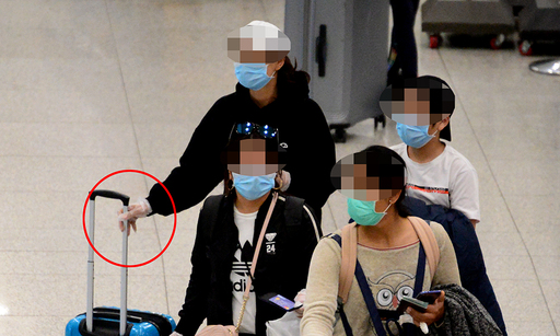 지난 12일 오전 인천 중구 인천국제공항에서 한 여행객이 일회용 장갑과 마스크를 착용한 채 이동하고 있다.