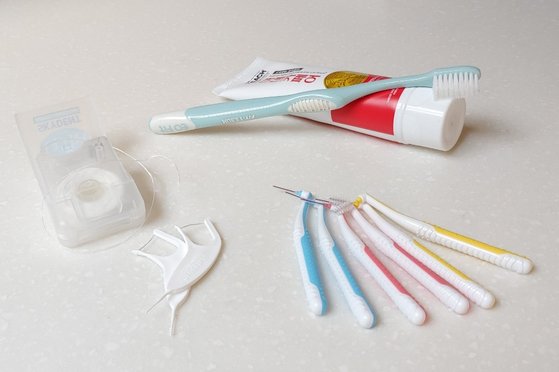 칫솔질 못지않게 중요한 것이 치아와 치아 사이의 청결을 위한 치실 사용이다. 치실은 이 사이에 끼인 것을 빼 주고 플라크(치태)도 제거해주는 효과가 있다. [사진 유원희]