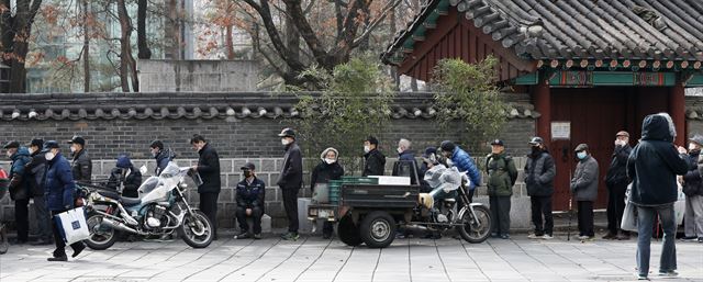 서울 종로구 원각사 노인급식소가 23일부터 신종 코로나 확산이 멎을 때까지 무료급식을 중단했다. 급식 중단을 하루 앞둔 22일 서울 종로구 탑골공원 원각사 무료급식소 앞에서 독거노인을 비롯한 소외계층 어르신들이 끼니를 잇기 위해 길게 줄을 서 차례를 기다리고 있다. 탑골공원 원각사 무료급식소는 운영을 계속한다. 뉴스1