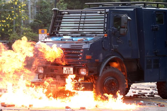 지난해 11월 시위대가 던진 화염병에 홍콩 경찰 차량이 불타고 있다. [로이터=연합]