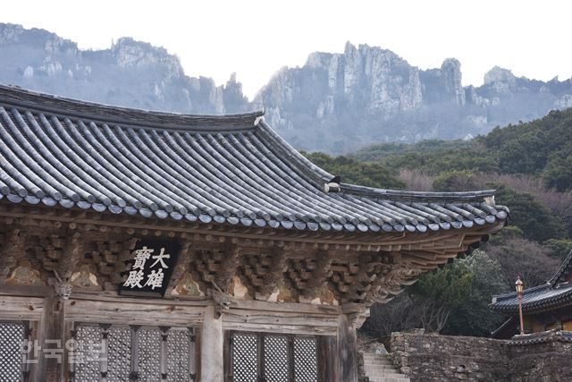 단청 없이 깔끔한 대웅보전 뒤로 달마산 바위 능선이 병풍처럼 펼쳐져 있다.