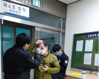 의정부지방법원 직원이 법정 입구에서 경매 응찰자의 체온을 확인하고 있다./사진= 지지옥션