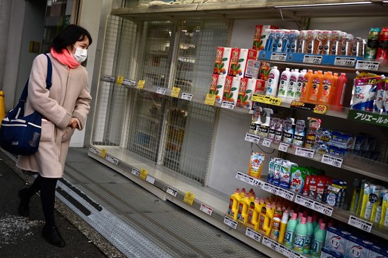 지난 1일 도쿄의 한 매장 앞을 지나고 있는 여성. 코로나 바이러스로 인해 일본 내에서 생필품 사재기가 계속되면서 이번에는 '화장지 대란'이 일어났다. [AFP=연합뉴스]