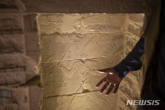 [사카라(이집트)=AP/뉴시스] 이집트 정부가 14년간의 복원 공사 끝에 '이집트 최초의 피라미드'인 조세르 피라미드(Djoser Pyramid)를 5일(현지시간) 다시 일반에 공개했다. 사진은 이집트 고고학자가 피라미드내 조각을 가르키고 있다. 2020.03.06
