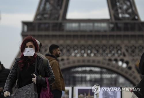 マスクをかけてパリエッフェル塔の前を通り過ぎる市民 [EPA=連合ニュース]