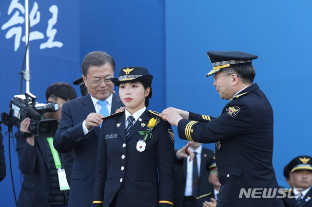 [아산=뉴시스]박영태 기자 = 문재인 대통령과 민갑룡 경찰청장이 12일 충남 아산시 경찰대학에서 열린 신임 경찰 경위.경감 임용식에 참석해 신임 경찰 어깨에 계급장을 달아주고 있다. 2020.03.12. since1999@newsis.com