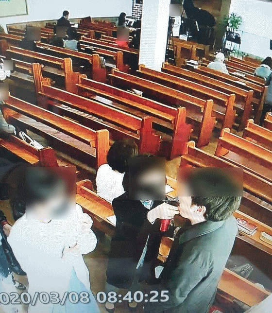 경기도 성남시 은혜의강 교회 관계자들이 예배 참석자 입에 소금물을 분사하고 있다. [사진 경기도]