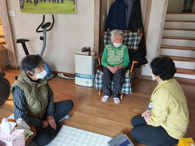 올해 97세로 신종 코로나바이러스 감염증(코로나19) 확진 판정을 받았다가 12일만에 완치된 황영주 할머니가 26일 경북 청도군 각남면 집에서 아들 홍효원(왼쪽)씨와 함께 청도군청 직원과 이야기를 나누고 있다. 청도군 제공