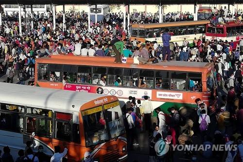 28일 고향으로 돌아가기 위해 인도 수도 뉴델리의 버스정류장에 몰려든 일용직 근로자와 가족들. [AFP=연합뉴스]