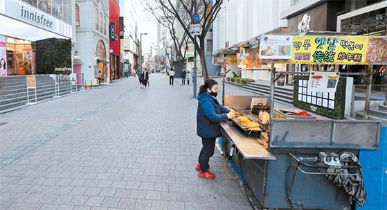 29일 한산한 서울 명동거리에서 한 상인이 음식 판매를 준비하고 있다. [뉴시스]
