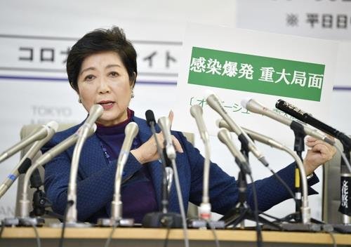 (도쿄 교도=연합뉴스) 고이케 유리코 일본 도쿄도 지사가 3월 25일 오후 도쿄도청에서 긴급 기자회견을 하던 중 '감염폭발 중대국면'이라고 쓴 카드를 들어 보이고 있다.