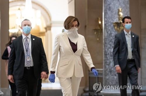 마스크 대신 스카프 착용한 펠로시 미 하원의장 미국 하원이 신종 코로나바이러스 감염증(코로나19) 대응을 위해 긴급 편성한 추가 예산 법안을 처리할 예정인 가운데 낸시 펠로시 하원의장이 23일(현지시간) 마스크 대용으로 스카프를 쓰고 의사당 내 집무실로 걸어가고 있다. [UPI=연합뉴스]