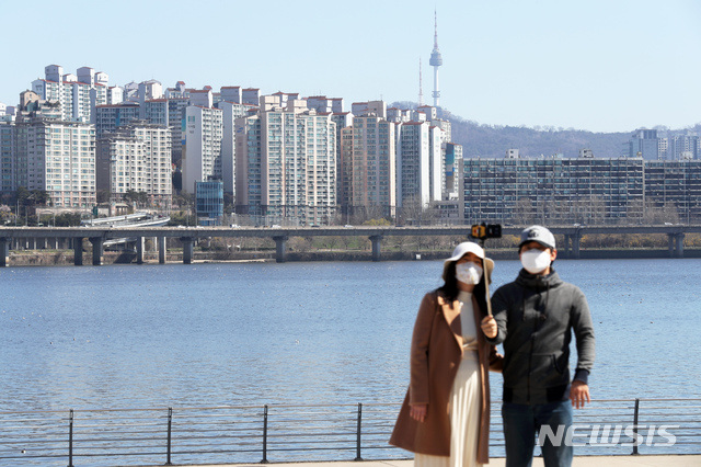 [서울=뉴시스] 이윤청 기자 = 전국 대부분 지역에서 미세먼지 농도 '보통' 수준을 기록한 22일 오전 서울 여의도 한강공원에서 시민들이 마스크를 쓴 채 기념촬영을 하고 있다. 2020.03.22.   radiohead@newsis.com