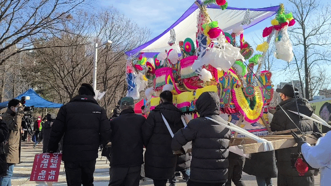 28일 서울 과천청사에서 열린 ‘추미애 법무부 사망 규탄 집회’에서 참가자들이 꽃상여를 들고 행진하고 있다. 박현주 기자