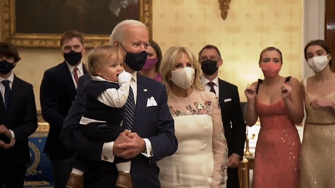 바이든 대통령이 20일 백악관에서 생후 8개월된 막내 손자 보를 안은 채 취임식 축하쇼를 TV로 보고 있다. 그는 음악에 맞춰 몸을 흔들며 손자를 기쁘게 해주려고 했다. 그의 옆에 질 바이든 여사도 음악에 맞춰 몸을 흔들고 있다. [바이든 취임준비위원회 유튜브 캡처]