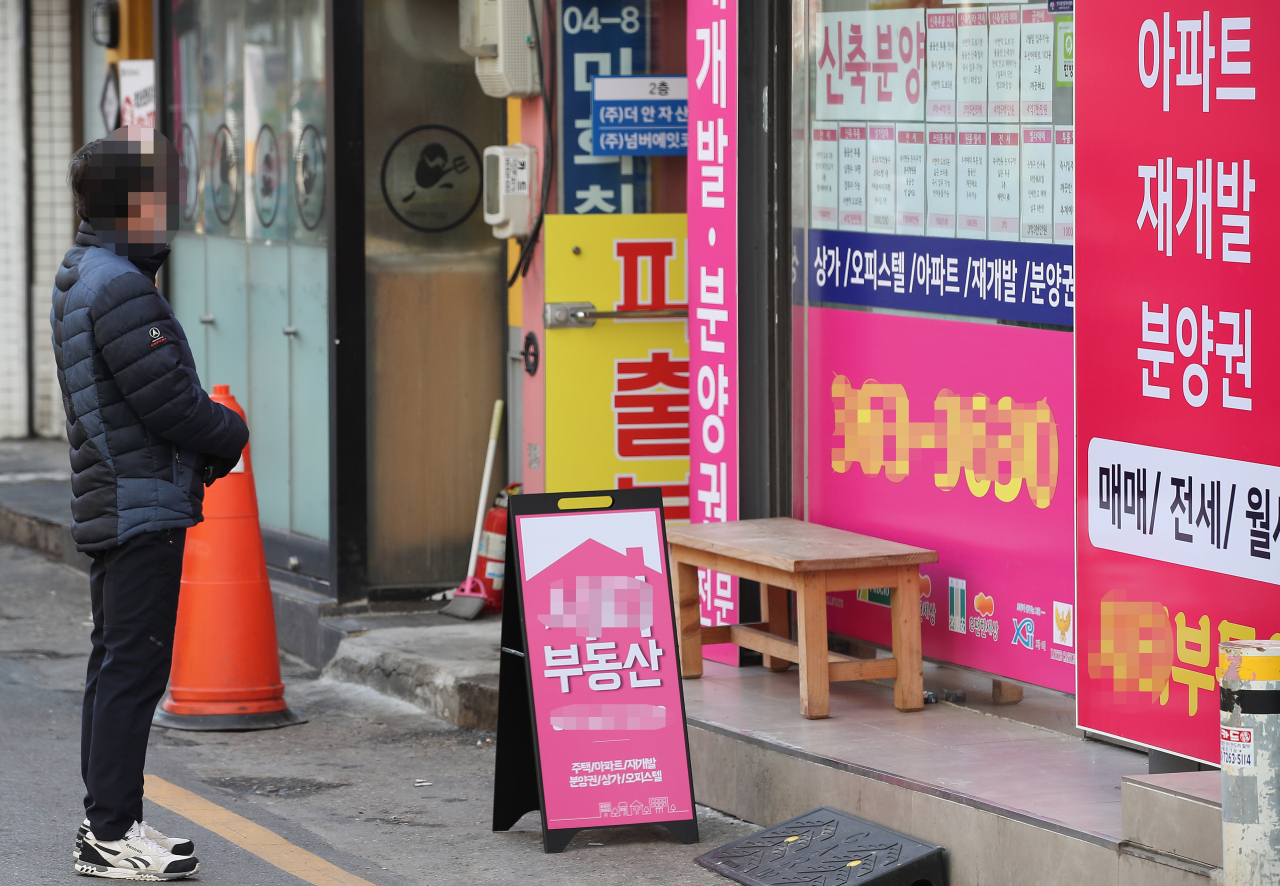 서울 서대문구의 한 부동산 사무실 앞에서 한 시민이 인근 아파트들의 매매와 전세, 월세 가격을 살펴보고 있다. [연합]