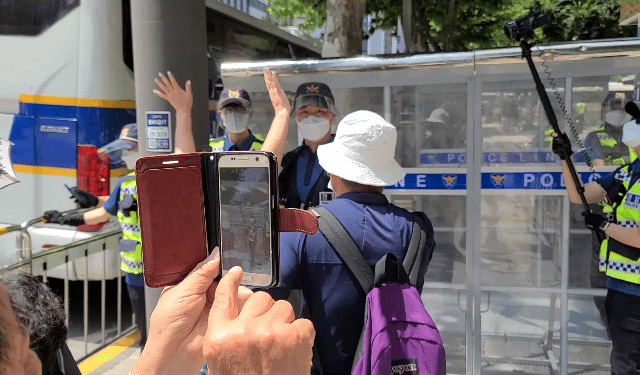 15일 오후 서울 종로구 소재 인도에서 진입이 막힌 시민들의 모습. 한 시민은 체증하는 경찰 카메라 앞에서 손을 흔들고 있다./허진 기자