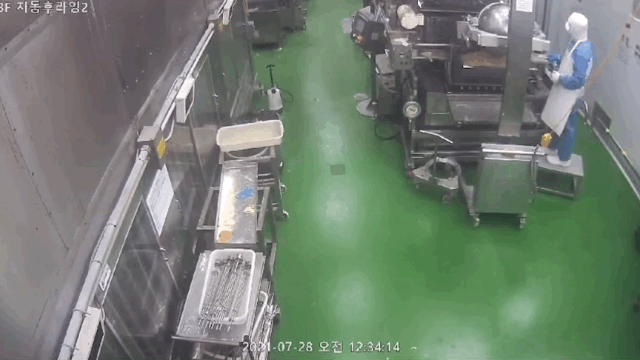 '던킨 위생 불량' 제보 영상 촬영자로 보이는 직원이 설비 외부에서 고무주걱으로 기름을 긁어내는 것으로 보이는 장면. / 영상=비알코리아 제공