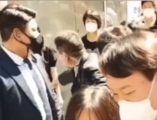 지난달 11일 대구 동성로에서 윤석열 전 검찰총장 측 관계자로 보이는 남성이 젊은 여성의 팔목을 잡고 끌어 당기는 모습. 윤 전 총장은 다른 시민과 대화를 나누고 있다./온라인 커뮤니티