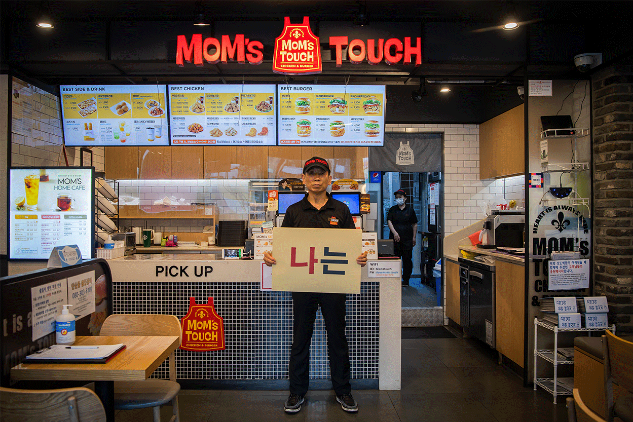 지난달 27일 서울 동작구 맘스터치 상도역점에서 점주 황성구(62)씨가 '나는 본사의 노예가 아니다'라고 적힌 피켓을 들고 있다.