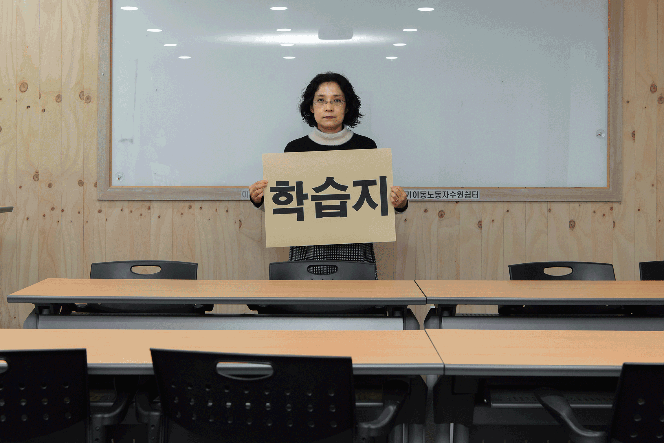 지난 14일 경기 수원시 이동노동자 쉼터에서 구몬학습 교사 김미례(55)씨가 '학습지 교사도 노동자다'라고 적힌 피켓을 들고 있다.