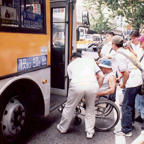 버스는 지하철과 더불어 보편적인 대중교통수단으로 꼽힌다. 하지만 휠체어 이용자는 타기가 쉽지 않다. 저상버스가 많지 않아서다. 사진은 버스를 타는데 어려움을 겪고 있는 휠체어 이용자. 경향신문 자료사진