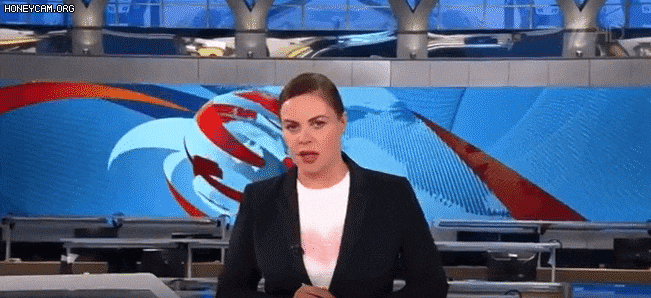 14일(현지 시각) 러시아 국영방송 채널원에서 생방송 뉴스가 진행되던 중 한 여성이 '전쟁 반대' 라고 쓴 종이를 들고 나타났다./트위터