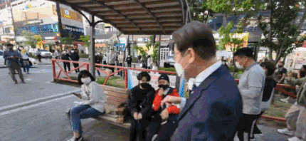 이재명 전 경기지사가 유세 중 연설을 하기 위해 시민이 앉아 있는 벤치에 올라가고 있는 모습. 온라인 커뮤니티 캡처