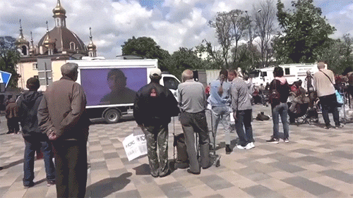 마리우폴에 배치된 대형TV가 달린 밴을 바라보고 있는 시민들의 모습./트위터