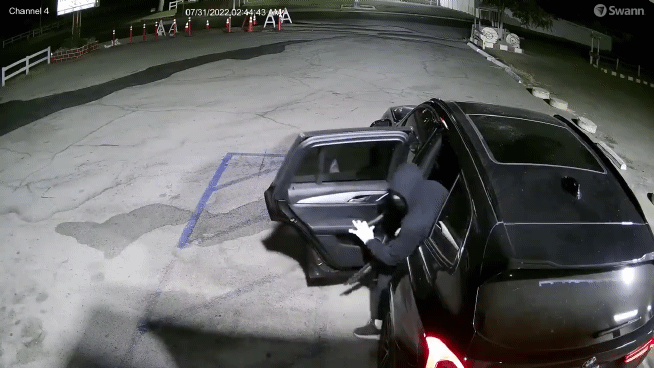 옥외 주차장에서 대기하던 강도 일행이 총성이 들리자 황급히 차안으로 들어가고 있다. [폭스11]